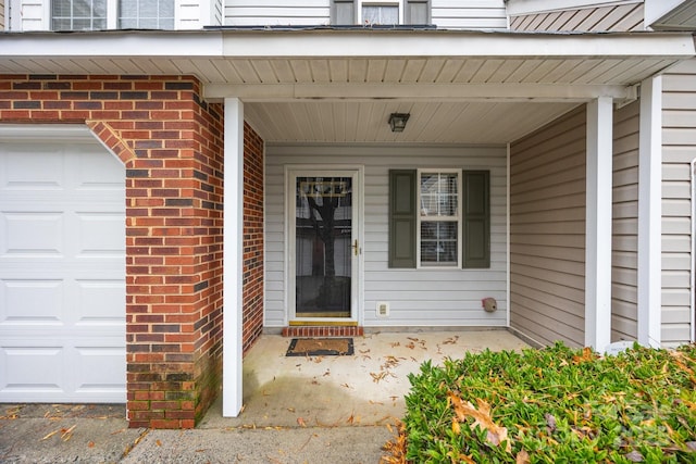 entrance to property with a garage and a porch