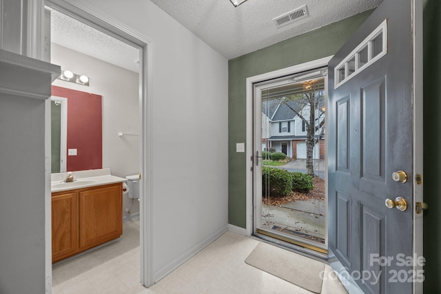 entrance foyer featuring sink and a textured ceiling