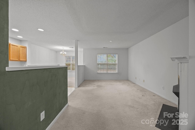 carpeted living room with a textured ceiling and a notable chandelier