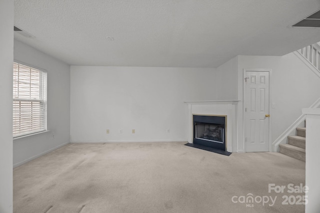 unfurnished living room with light carpet and a textured ceiling