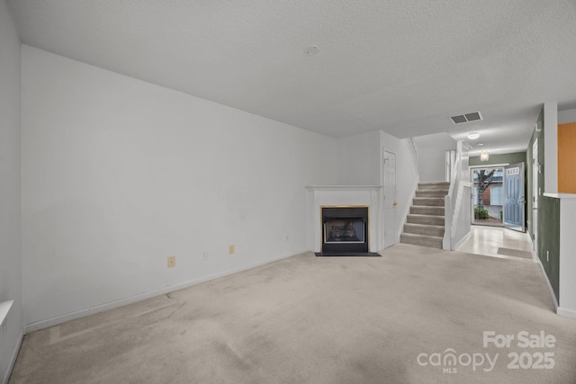 unfurnished living room with light carpet and a textured ceiling