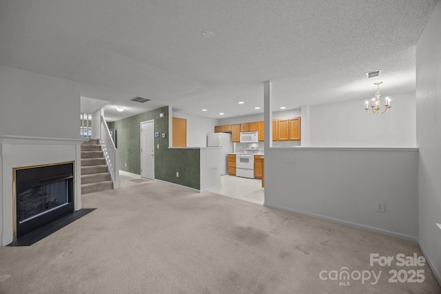 unfurnished living room with light colored carpet and a textured ceiling