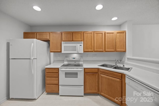 kitchen featuring white appliances, sink, and a textured ceiling