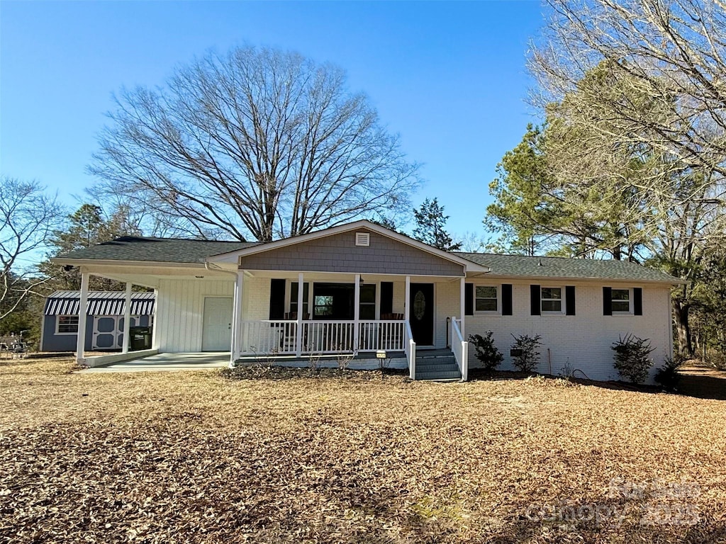 single story home featuring covered porch and a carport