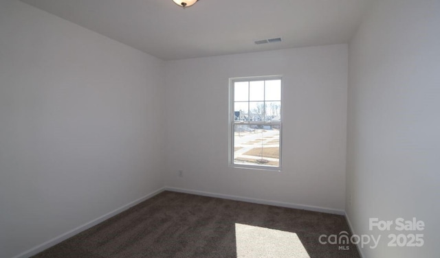 carpeted spare room with visible vents and baseboards