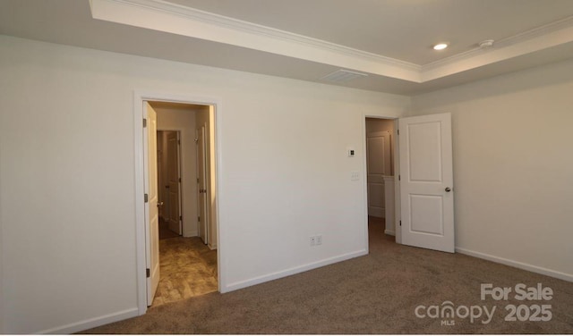 unfurnished bedroom with baseboards, ornamental molding, carpet floors, recessed lighting, and a raised ceiling