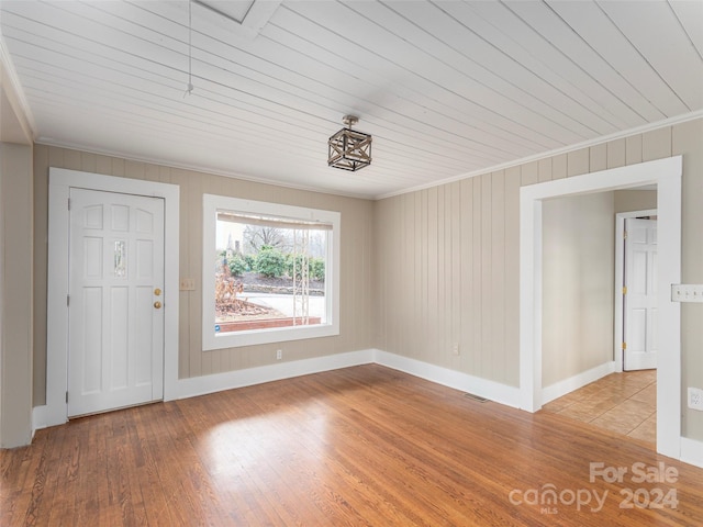 interior space with wood-type flooring, crown molding, and wood ceiling