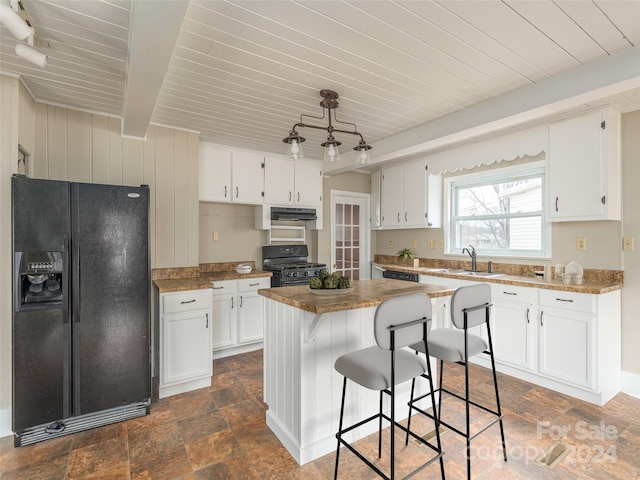 kitchen featuring white cabinets, a kitchen island, and black appliances