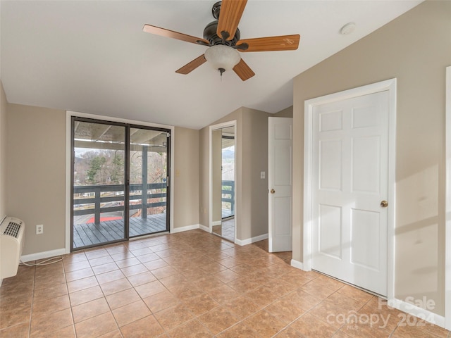 empty room featuring vaulted ceiling, ceiling fan, and light tile patterned flooring