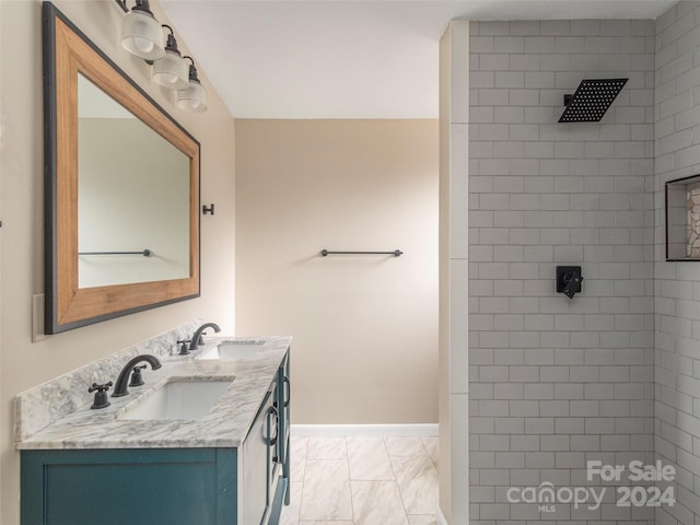 bathroom with a tile shower and vanity