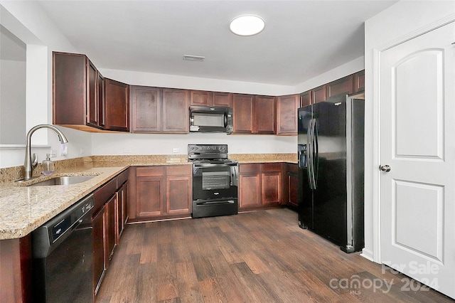 kitchen featuring light stone countertops, sink, black appliances, and dark hardwood / wood-style floors