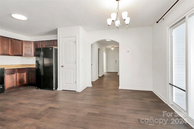 kitchen featuring dark wood-type flooring, black appliances, decorative light fixtures, a notable chandelier, and plenty of natural light