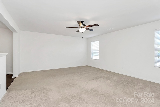 unfurnished room featuring a wealth of natural light, carpet, and ceiling fan