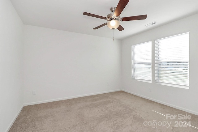 carpeted spare room featuring ceiling fan