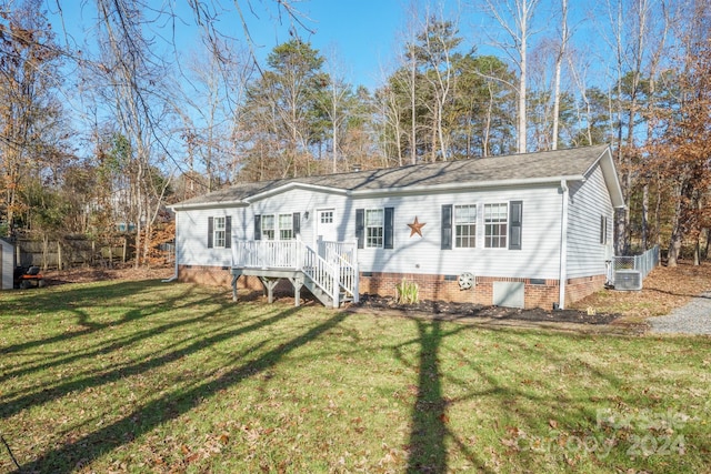 view of front facade with a front yard, a deck, and central air condition unit