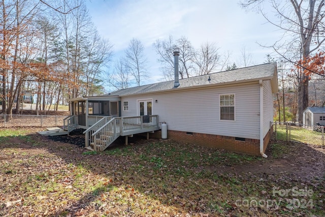 back of property featuring a deck and a sunroom