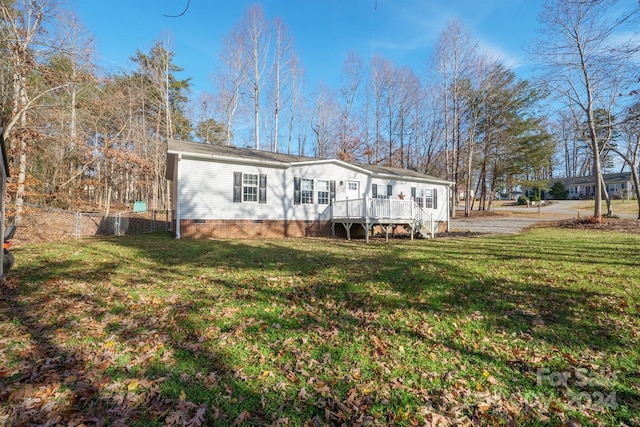 back of property featuring a deck and a yard