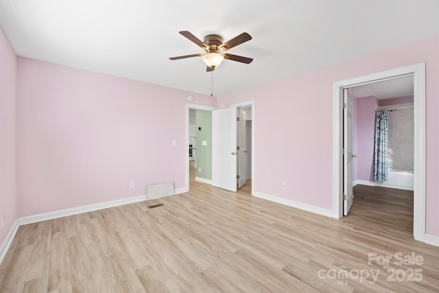 unfurnished bedroom featuring a spacious closet, light hardwood / wood-style flooring, a closet, and ceiling fan