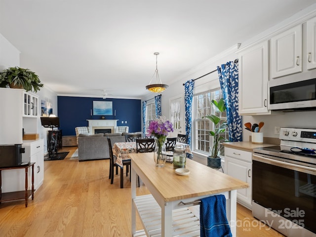 kitchen featuring white cabinetry, appliances with stainless steel finishes, and crown molding