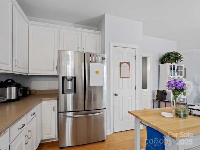 kitchen with white cabinetry, stainless steel fridge, and light hardwood / wood-style flooring