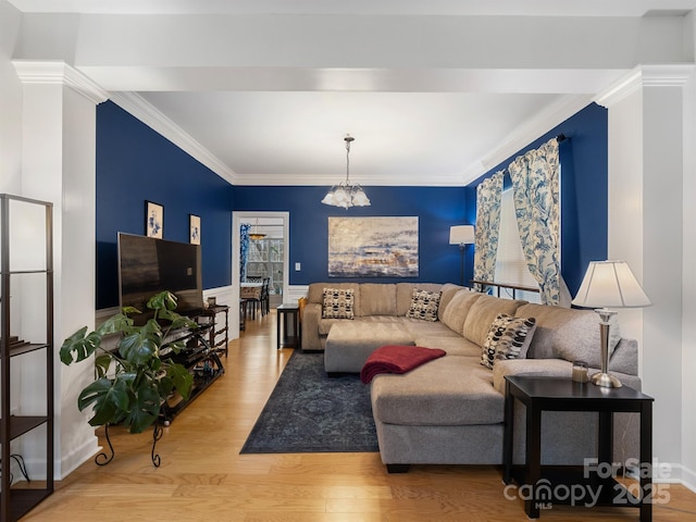 living room featuring an inviting chandelier, ornamental molding, and hardwood / wood-style floors