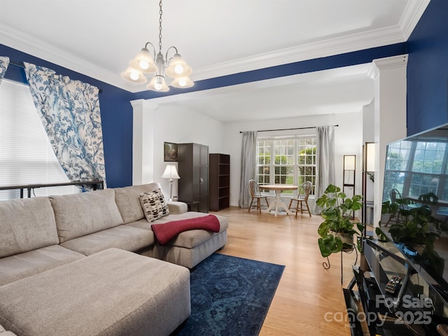 living room featuring hardwood / wood-style flooring, ornamental molding, and a chandelier