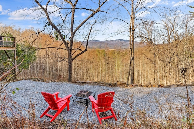 view of yard featuring a mountain view and an outdoor fire pit