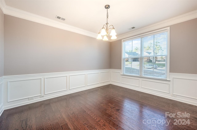 spare room with dark hardwood / wood-style floors, ornamental molding, and a notable chandelier