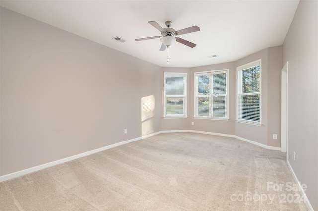 spare room featuring light colored carpet and ceiling fan