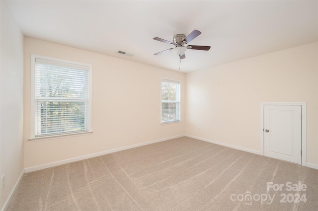 carpeted spare room featuring ceiling fan