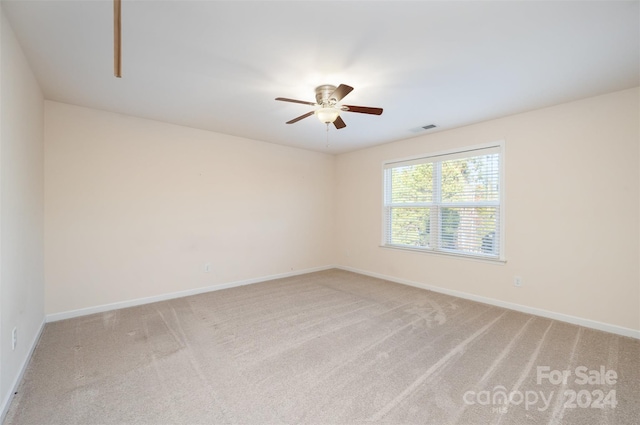 carpeted spare room featuring ceiling fan