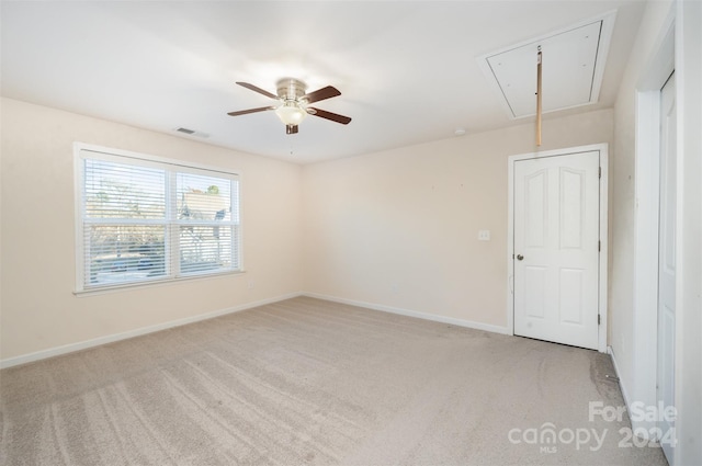 carpeted spare room featuring ceiling fan