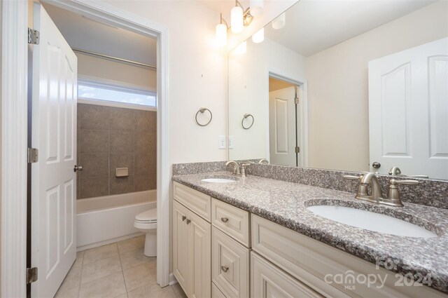 full bathroom featuring tile patterned floors, vanity, tiled shower / bath combo, and toilet