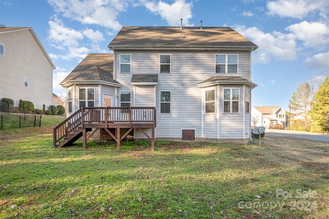 back of house featuring a lawn and a deck