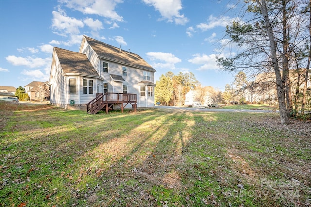 back of property with a lawn and a wooden deck