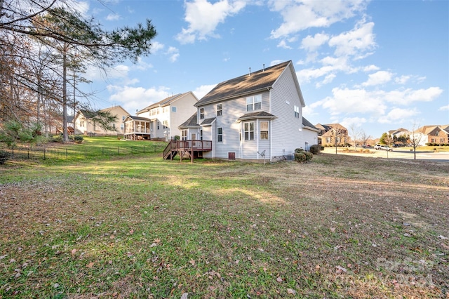 back of property with a lawn and a wooden deck