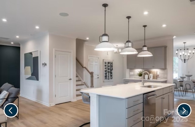 kitchen featuring a sink, light countertops, dishwasher, and gray cabinetry