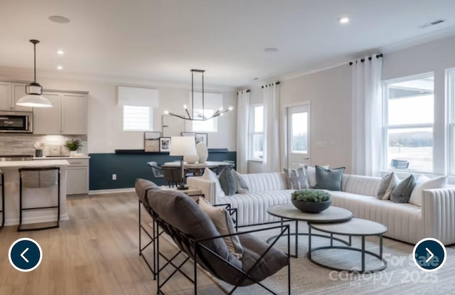 living area featuring light wood finished floors, plenty of natural light, and recessed lighting