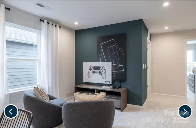 living area featuring light colored carpet, recessed lighting, visible vents, and baseboards