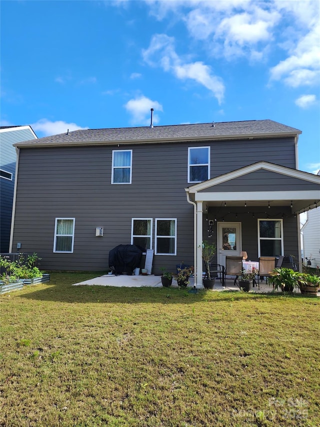 rear view of house with a yard, a vegetable garden, and a patio