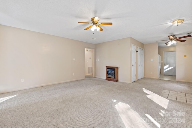 unfurnished living room featuring ceiling fan and light colored carpet