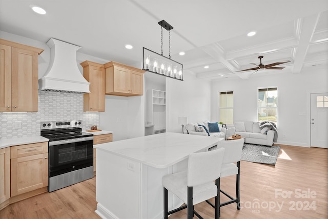 kitchen featuring light hardwood / wood-style flooring, premium range hood, decorative light fixtures, stainless steel electric stove, and a breakfast bar