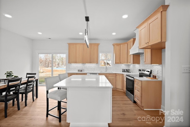 kitchen featuring a center island, light wood-type flooring, stainless steel appliances, and light brown cabinets