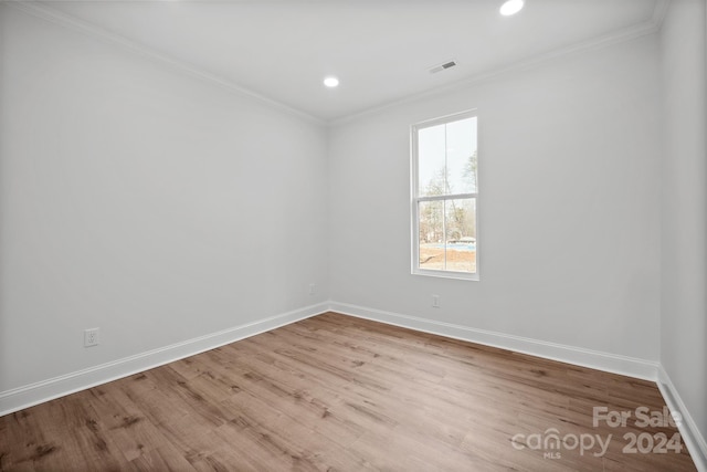 empty room with light hardwood / wood-style flooring and ornamental molding