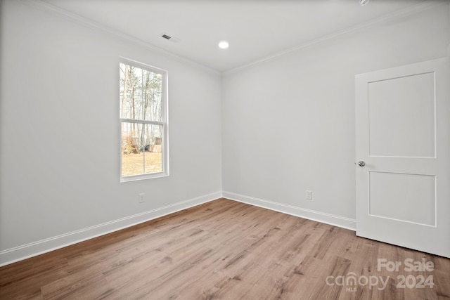 unfurnished room with ornamental molding and light wood-type flooring