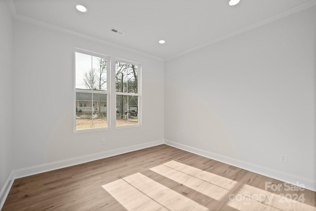 empty room with ornamental molding and light hardwood / wood-style flooring