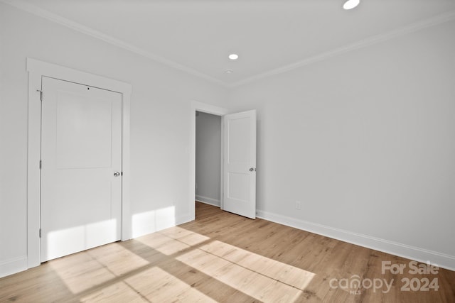 unfurnished bedroom with a closet, light hardwood / wood-style flooring, and ornamental molding