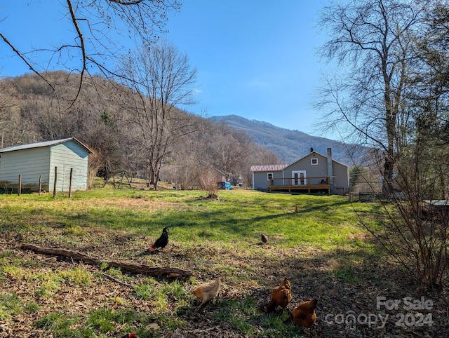 view of yard with a deck with mountain view