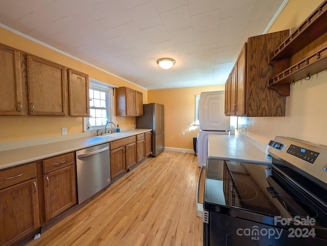 kitchen with crown molding, sink, light wood-type flooring, and appliances with stainless steel finishes