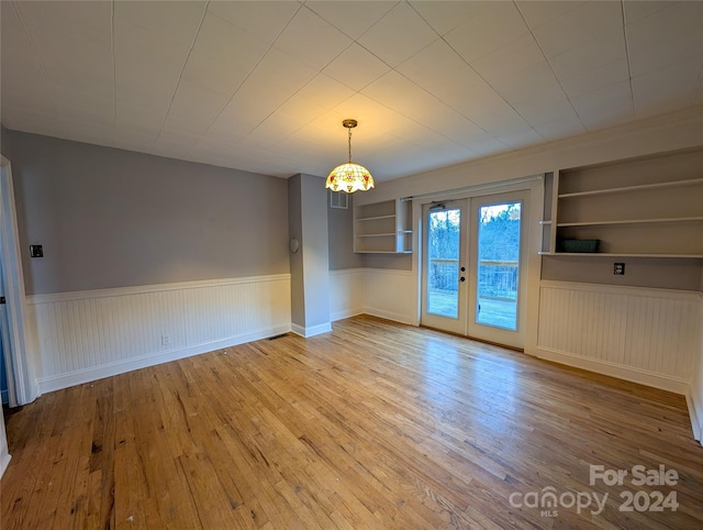 interior space featuring built in shelves, hardwood / wood-style floors, and french doors